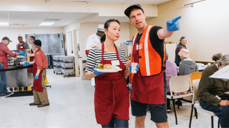 An event coordinator directs event staff carrying a plate of food