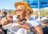 Female attendee eating at the Black Food Truck Festival